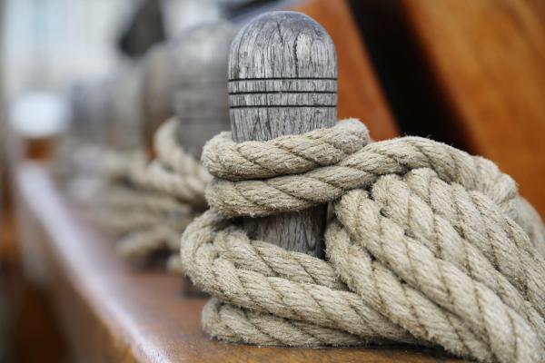 Selective focus shot of a wooden bollard with a tied rope